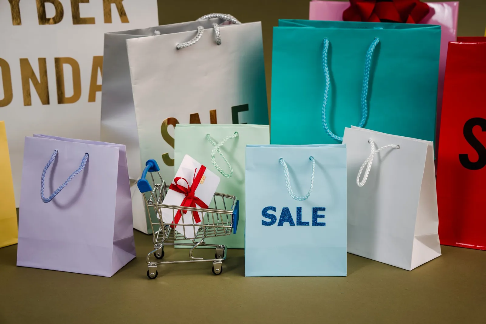 Sale লেখা রঙিন shopping bag-এর পাশে ছোট cart ও gift box