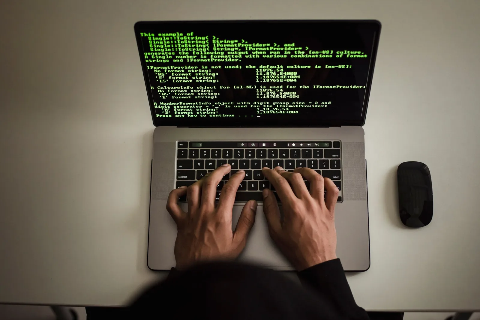 Laptop screen-এর code দেখে keyboard-এ কাজ করছেন একজন developer
