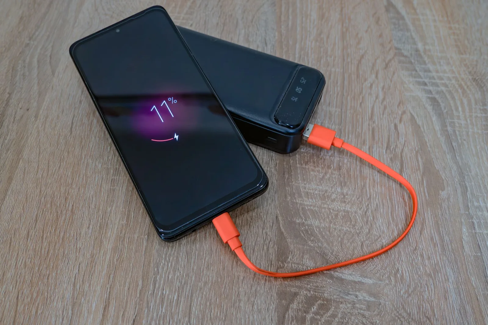 Power bank-এর orange cable দিয়ে smartphone charge হচ্ছে