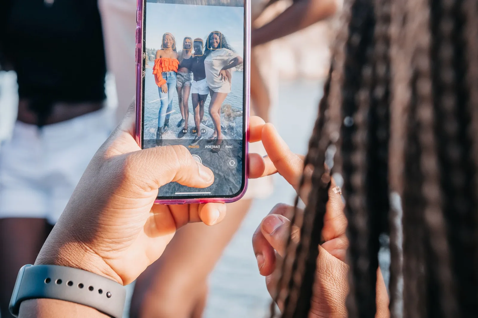 Smartphone screen-এ group photo দেখে মুহূর্তটি review করছেন একজন ব্যক্তি