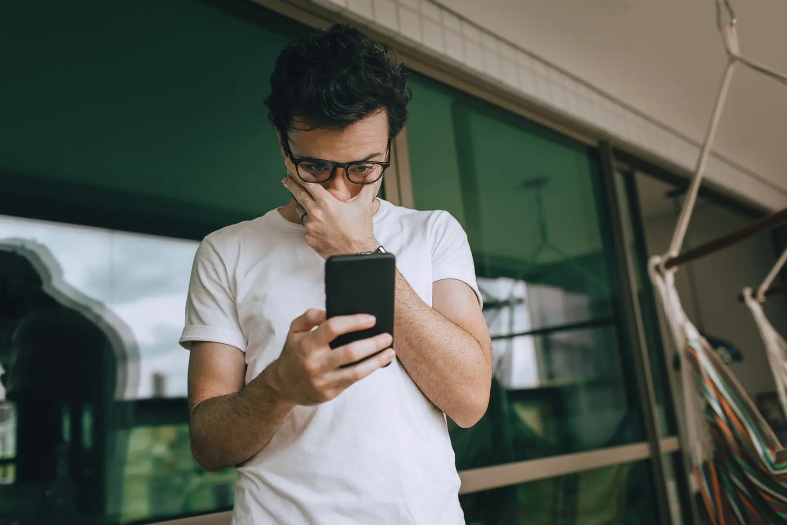 একজন ব্যক্তি smartphone screen দেখছেন এবং নিজের screen time অভ্যাস নিয়ে ভাবছেন
