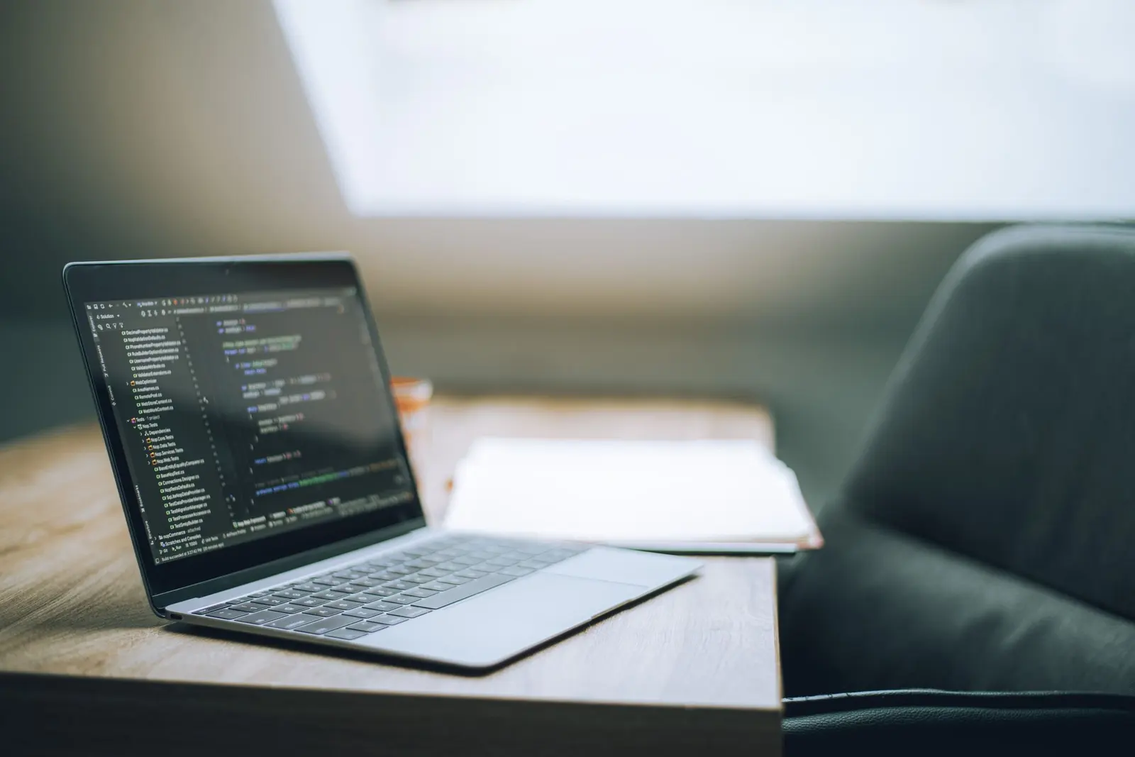 জানালার পাশে desk-এ code খোলা laptop