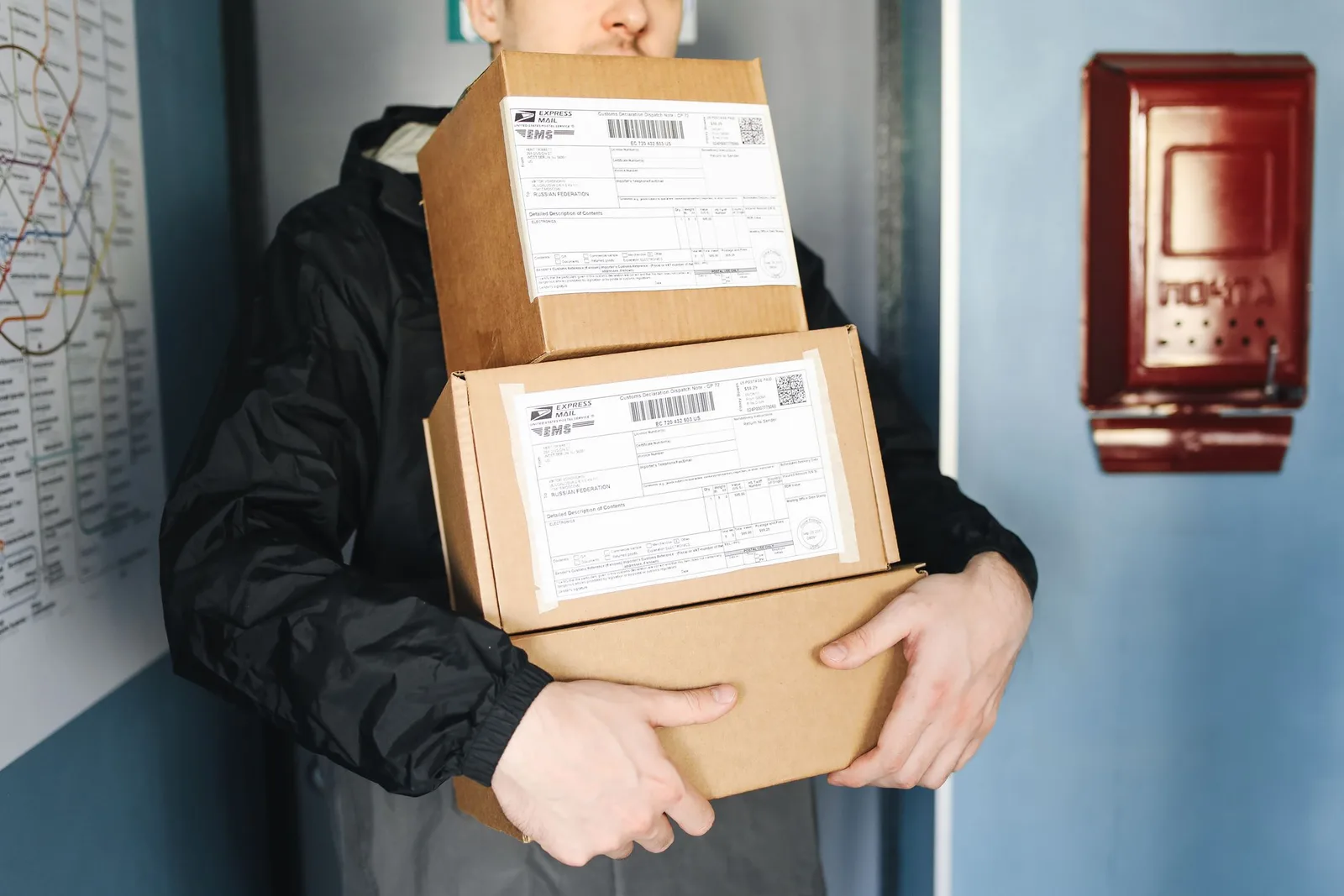 Delivery কর্মী দুটি labelled cardboard package হাতে ধরে আছেন