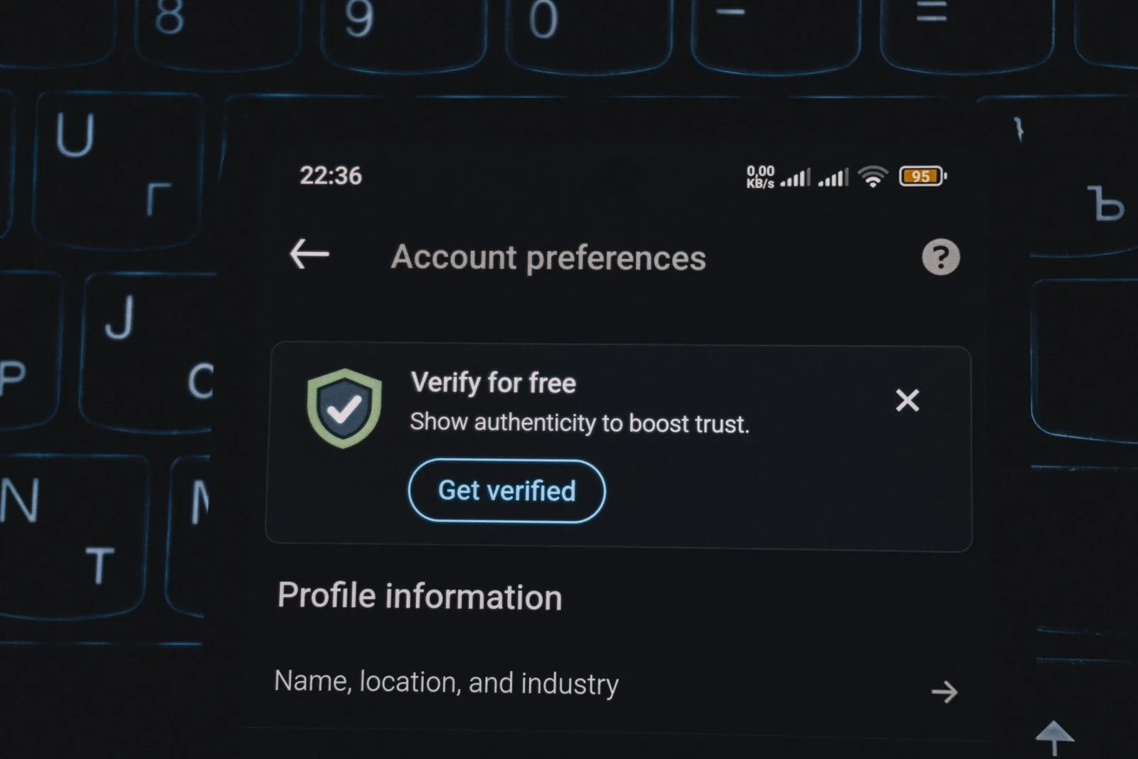 Smartphone screen-এ account verification alert ও keyboard দেখা যাচ্ছে